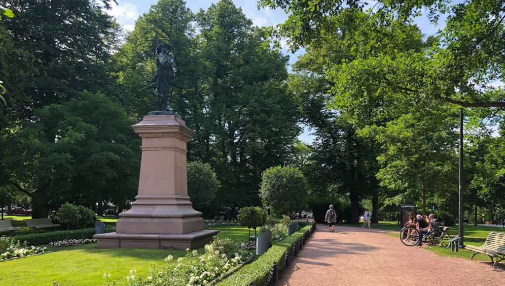 Vehreä Tuomiokirkonpuisto, jossa vasemmalla kukkien istutusalue ja oikealla turkulaisten suosima, puiston läpi vievä kulkuväylä.