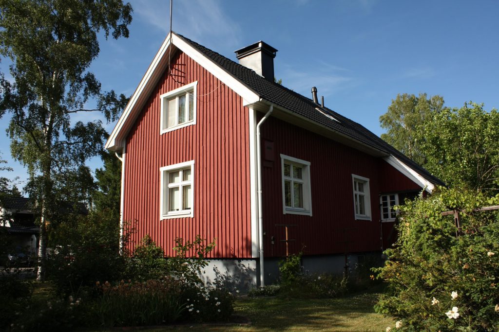 Punainen puinen talo vehreän puutarhan ympäröimänä Turun Kärsämäessä rauhallisella asuinalueella.