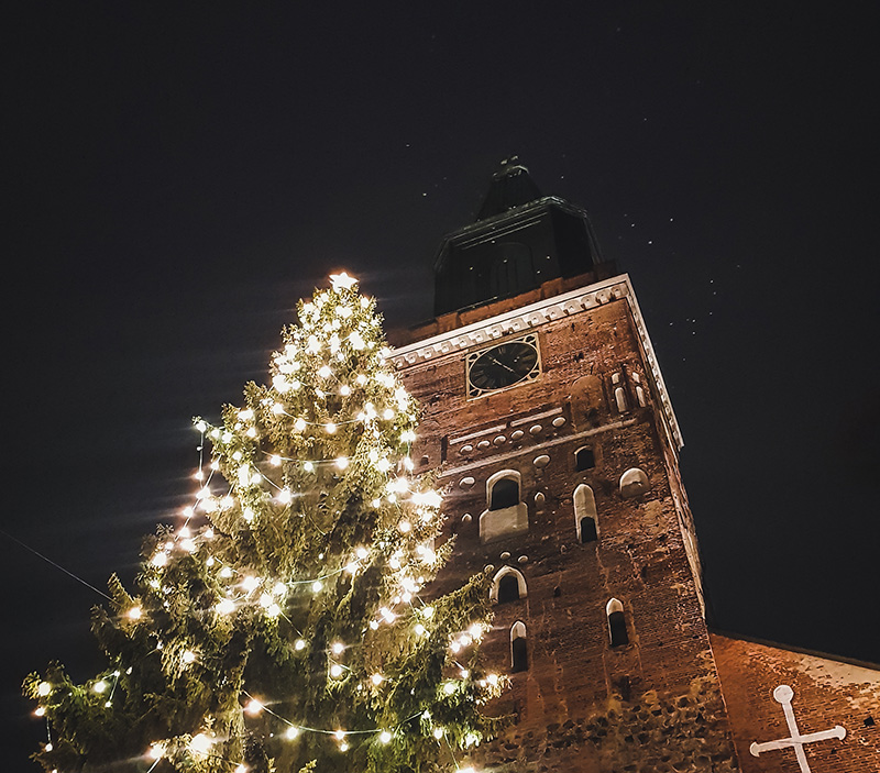 Turun Tuomiokirkko ja sen edessä valoin koristeltu joulukuusi tummaa yötaivasta vasten.