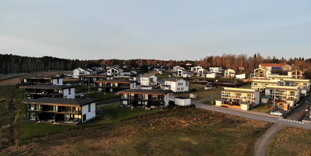 Moderneja asuntoja sekä niiden takana kohoava metsä rauhallisella alueella Voivalan asuinalueella Kaarinassa.