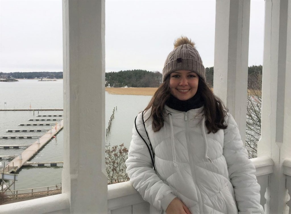 Spanish exchange student Noemi wearing a winter jacket on a terrace by the sea in Turku. 