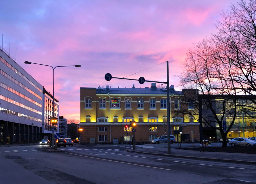Turun Kupittaalla uutta ja vanhaa arkkitehtuuria vaaleanpunaisessa auringonlaskussa.