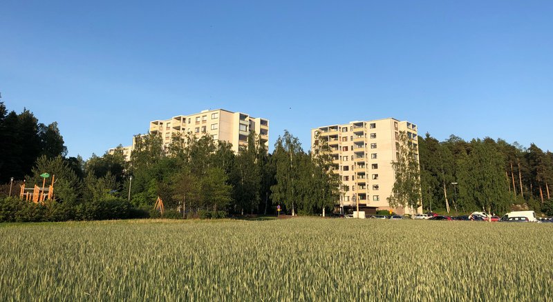 Turun Härkämäen kerrostaloja pellon laidalla ja metsän ympäröimänä.