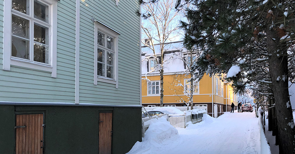Kaksi puutaloa lumisen tien varrella Turussa Nummen asuinalueella.