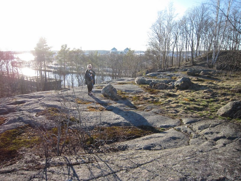 Timon vaimo seisomassa kallioisen Korppolaismäen päällä, jonka takana siintää Aurajoki ja Turun linna.