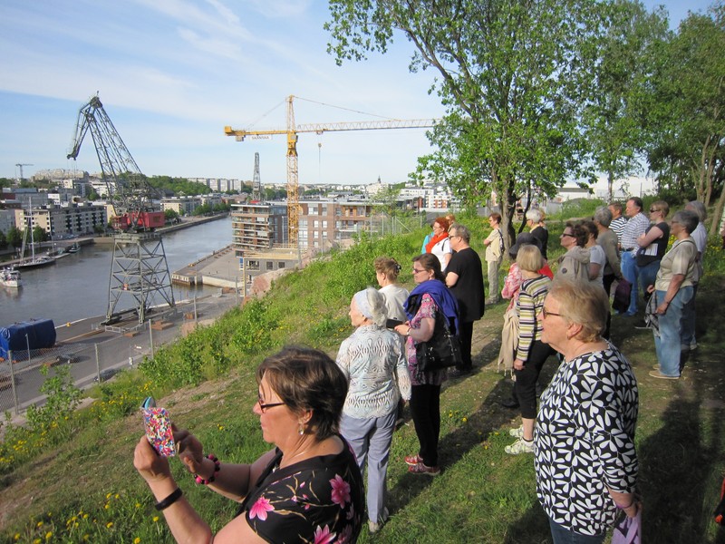 Joukko ihmisiä Turkuseura ry:n järjestämällä opastetulla kävelykierroksella Korppolaismäen päällä.