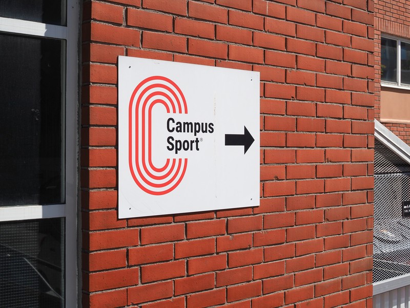 Campus Sportin kyltti punaisen tiilirakennuksen seinässä Turun linja-autoaseman läheisyydessä.