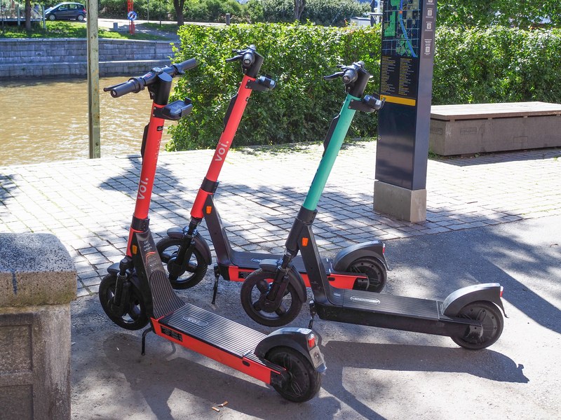 Three electric scooters side by side along the Aurajoki in Turku.