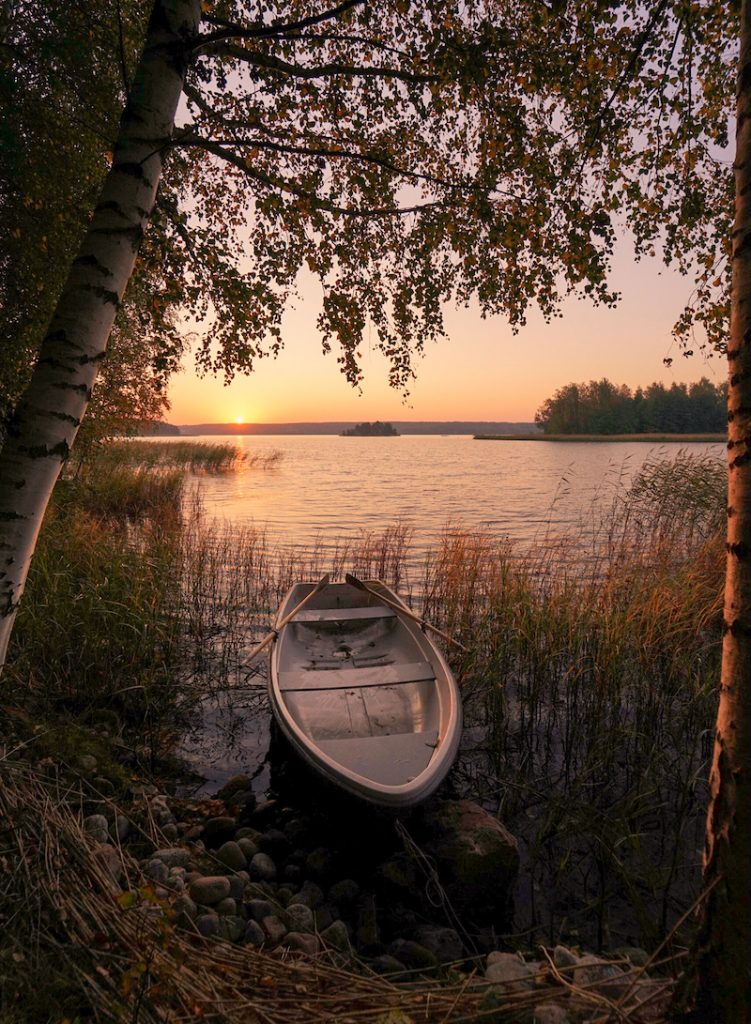 Soutuvene Kemiönsaaressa rannalla puiden ja kaislojen kehystäessä merimaisemaa.