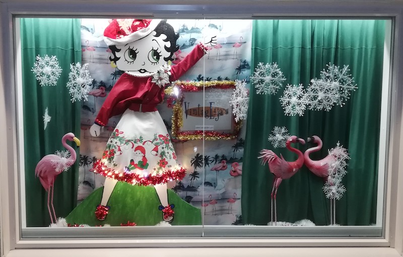 Raisiolaisen yrityksen VintagEijan jouluikkuna, jotta Betty Boo hahmo jouluasussa, vihreät verhot ja flamingoja.