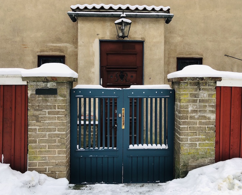 Casa Haartmanin sininen portti, kiviset pylväät ja etuovi.