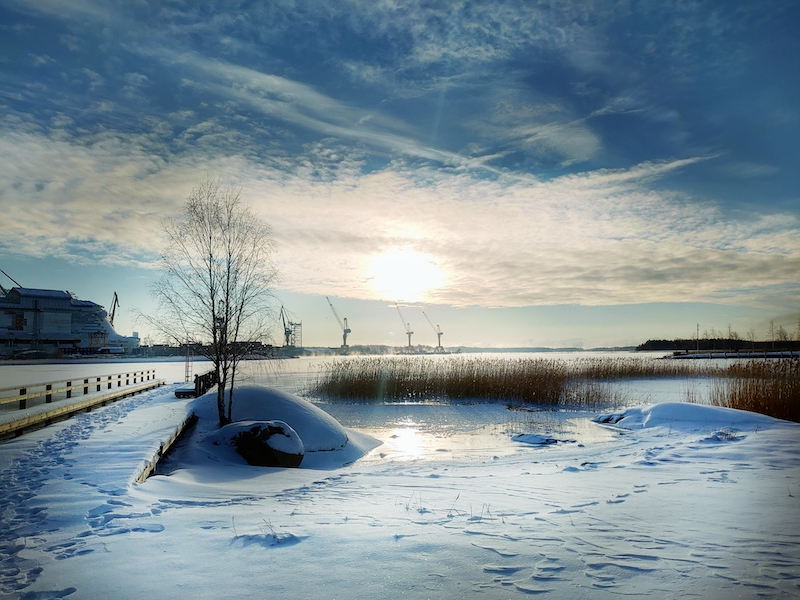 Aurinkoinen luminen maisema merelle ja Pernon telakan nostureille Raision satamasta.