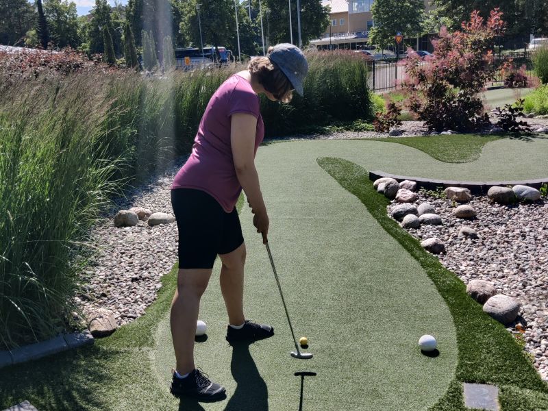 The author of the blog, Katerina, is at the Parainen Centris Adventure Golf Course, preparing to hit the ball.