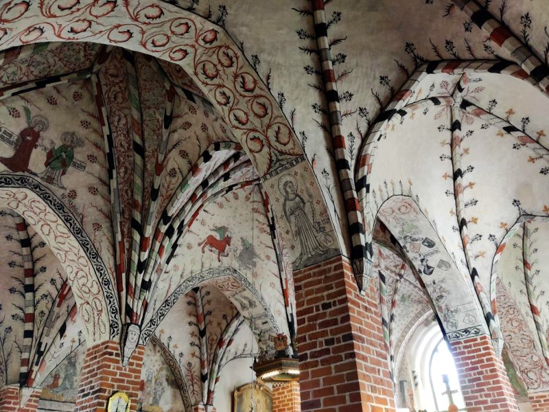 The picture shows colorful and well-preserved wall and ceiling paintings of the Church of the Holy Cross in Taivassalo. 