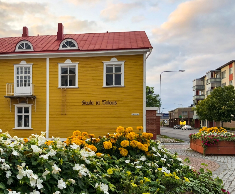 Keltainen puurakennus keskustassa, jonka seinässä lukee "Rauta ja Talous".