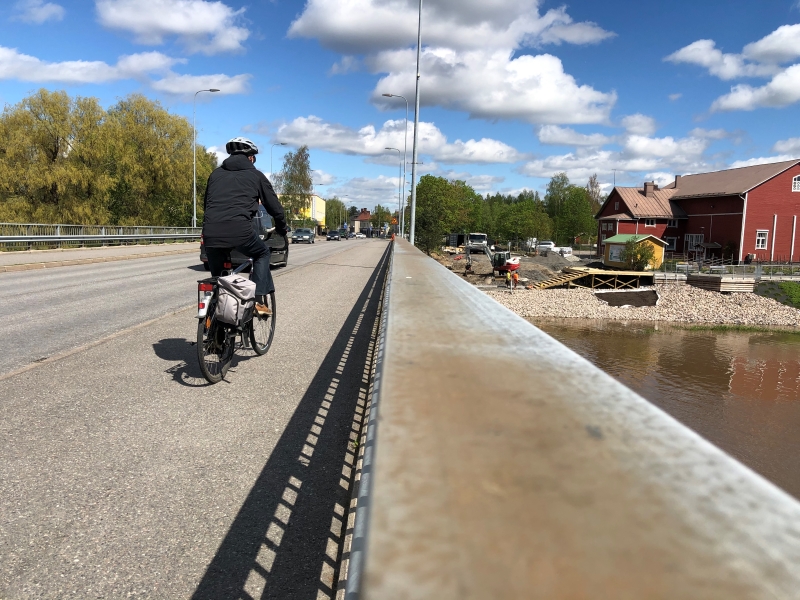 Ihminen pyöräilee sillalla.