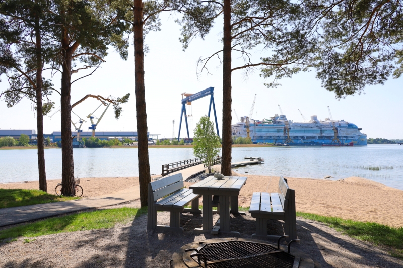Piknik-pöytä Playa del Raision uimarannalla, taustalla näkyy Meyer Turun telakka