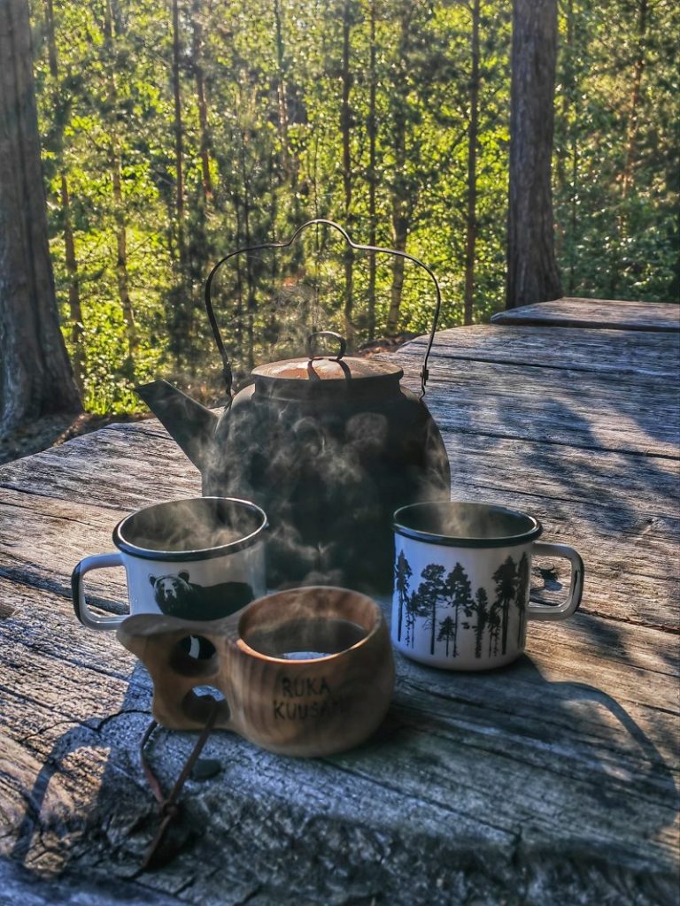 Höyryävät kahvit luonnon keskellä.