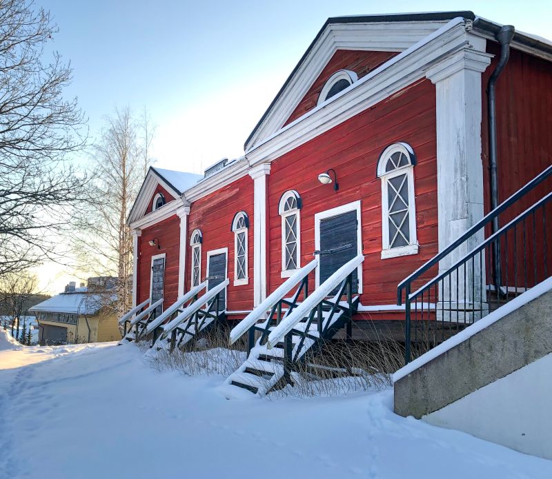 Punaiset puurakennukset lumisessa maisemassa.