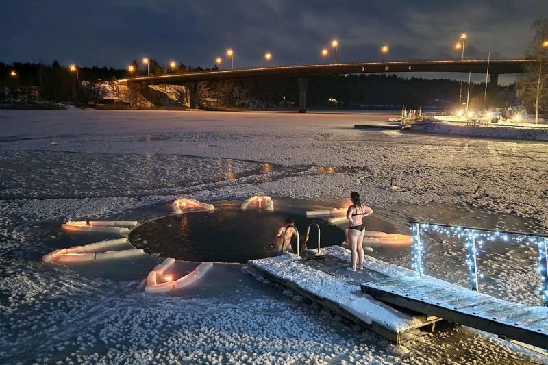 Merimaskun rantamakasiinin avanto iltavalaistuksessa, uimari avannossa ja laiturilla.